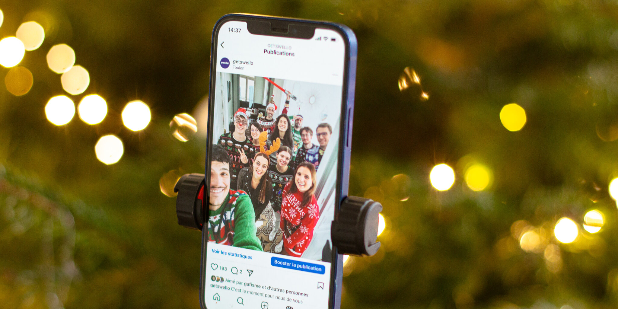 Téléphone sur un profil Instagram (réseaux sociaux) devant un sapin de noël
